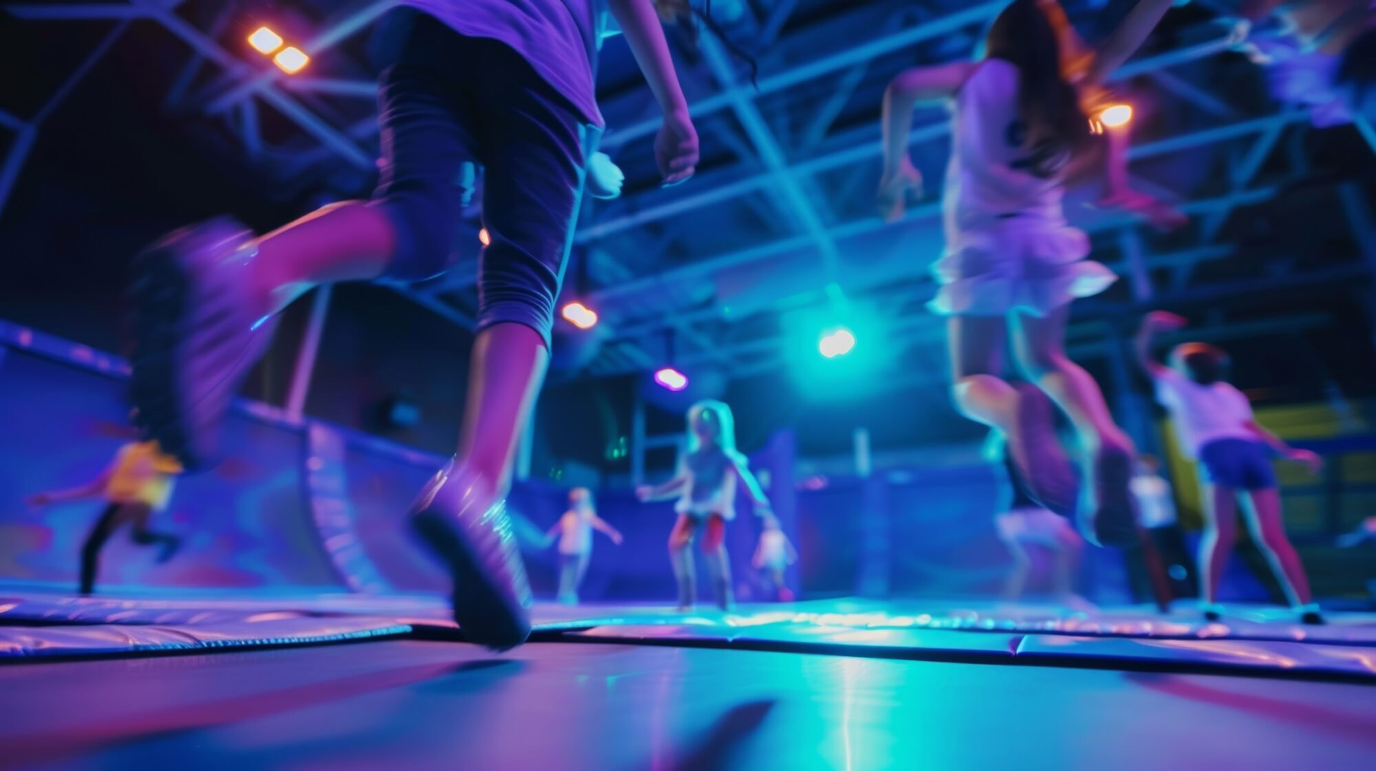 Unfocused vision of kids jumping and flipping in an indoor trampoline park